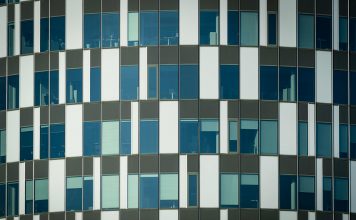 Close-up of a modern office building facade with geometric patterns and glass windows.