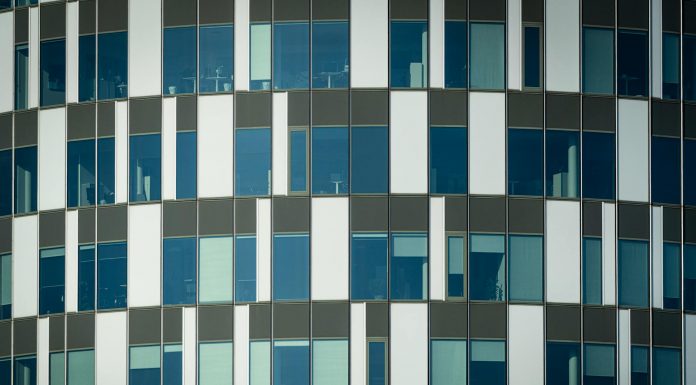 Close-up of a modern office building facade with geometric patterns and glass windows.