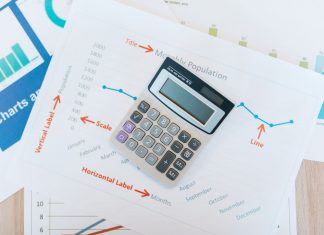 Calculator placed on financial graphs and reports showcasing data analysis and business documentation.