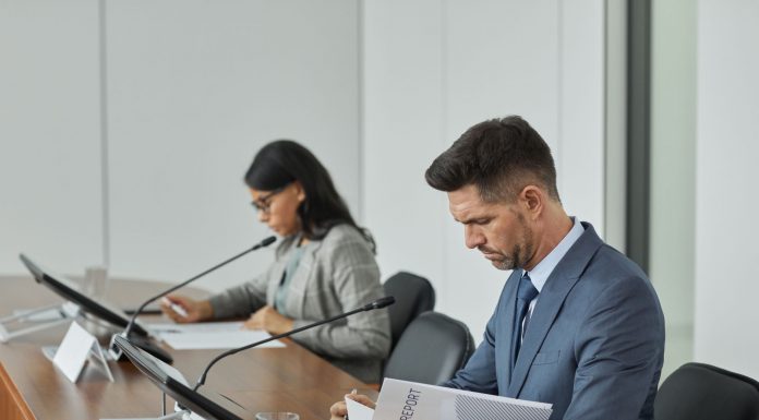 Jersey City School Board Approves Promotions, Downtown Rezoning Study Business professionals in a conference setting, focusing on documents and reports.