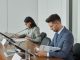 Business professionals in a conference setting, focusing on documents and reports.