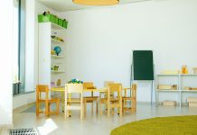 A well-lit, colorful kindergarten classroom with chairs, tables, and educational materials.