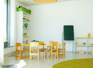 A well-lit, colorful kindergarten classroom with chairs, tables, and educational materials.