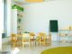 A well-lit, colorful kindergarten classroom with chairs, tables, and educational materials.
