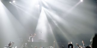 DJ performing in a lively nightclub with a crowd enjoying the vibrant atmosphere.