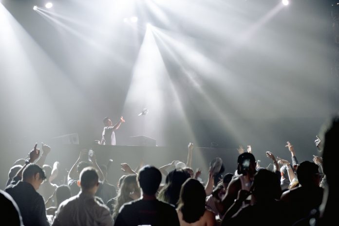 DJ performing in a lively nightclub with a crowd enjoying the vibrant atmosphere.