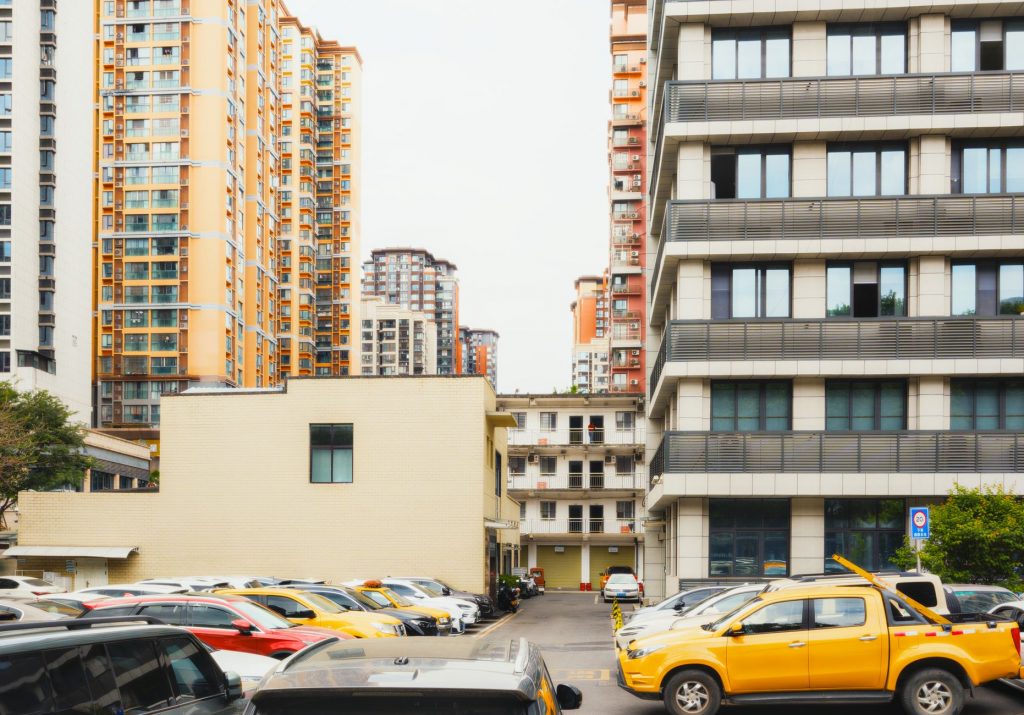 High-rise apartment buildings with parked cars in front captured in Sichuan, China.