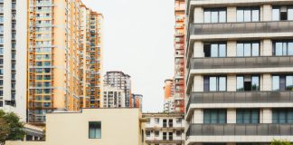 Journal Square Tower Plan Brings 150 Public Parking Spots, Affordable Units High-rise apartment buildings with parked cars in front captured in Sichuan, China.
