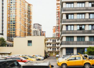 High-rise apartment buildings with parked cars in front captured in Sichuan, China.