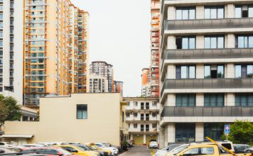 High-rise apartment buildings with parked cars in front captured in Sichuan, China.