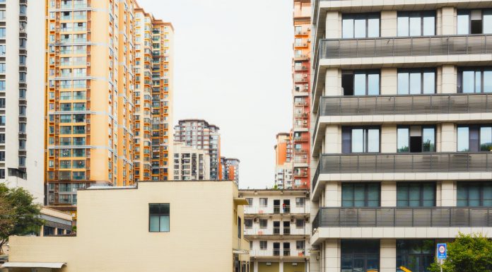 High-rise apartment buildings with parked cars in front captured in Sichuan, China.