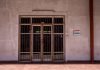 Judge lifts order blocking state oversight of Heights hospital closure A rustic iron gate in a textured wall with a warning sign, captured in bright daylight.