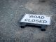 ÚLTIMA HORA: Cierres viales y restricciones en Hoboken para el 4 de julio A road closed sign lies on a gravel pathway, indicating a blocked road ahead.