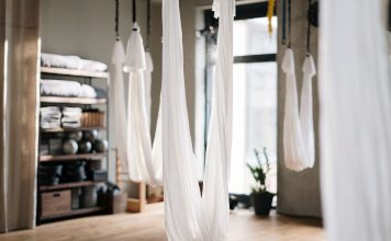 A peaceful yoga studio featuring aerial yoga hammocks for fitness and relaxation.