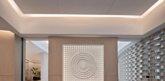 Spacious modern yoga studio interior featuring a striking wall art piece and yoga mats on wooden flooring.