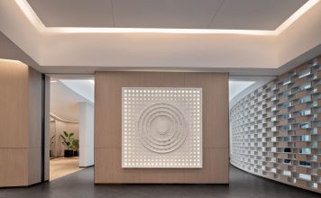 ÚLTIMA HORA: CorePower Yoga se suma a Starbucks en nuevo edificio de Hoboken Spacious modern yoga studio interior featuring a striking wall art piece and yoga mats on wooden flooring.