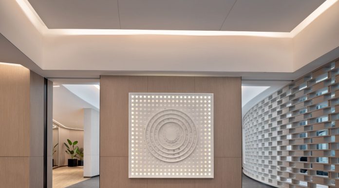 Spacious modern yoga studio interior featuring a striking wall art piece and yoga mats on wooden flooring.