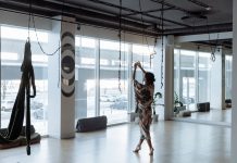 Woman practicing yoga gracefully in a modern, airy studio with natural light streaming in.