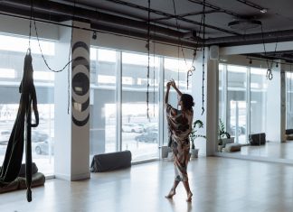 Woman practicing yoga gracefully in a modern, airy studio with natural light streaming in.