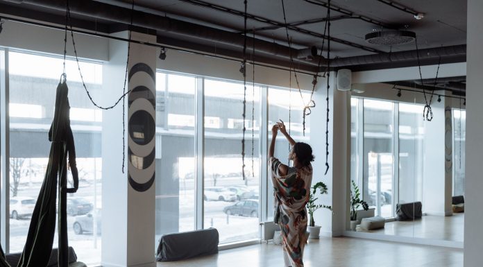 Woman practicing yoga gracefully in a modern, airy studio with natural light streaming in.