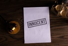 Close-up of legal document stamped 'Innocent' beside a gavel on a wooden desk.