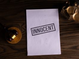 Close-up of legal document stamped 'Innocent' beside a gavel on a wooden desk.