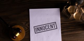 Close-up of legal document stamped 'Innocent' beside a gavel on a wooden desk.