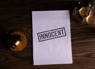 Close-up of legal document stamped 'Innocent' beside a gavel on a wooden desk.