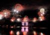 ÚLTIMA HORA: Fiesta del 4 de Julio regresa a Hoboken en 2026 Vibrant fireworks illuminate the night sky, reflecting brilliantly over the calm lake surface.
