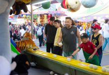 ÚLTIMA HORA: Fin de semana con más de 100 eventos en Hoboken y Jersey City A diverse group of people engages in a fun carnival game, surrounded by vibrant festival activities.