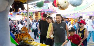 ÚLTIMA HORA: Fin de semana con más de 100 eventos en Hoboken y Jersey City A diverse group of people engages in a fun carnival game, surrounded by vibrant festival activities.