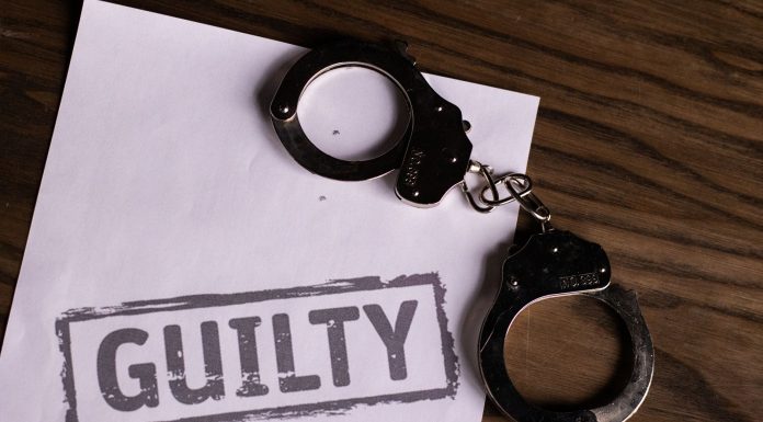 ÚLTIMA HORA: Hombre de North Bergen culpable por asesinato en Hoboken Top view of handcuffs on paper with 'GUILTY' text, symbolizing a verdict or crime.