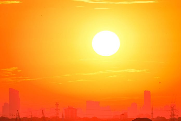 ltima-hora-jersey-city-emite-alerta-por-ola-de-ca A city skyline silhouetted against a vivid, orange sunset sky.