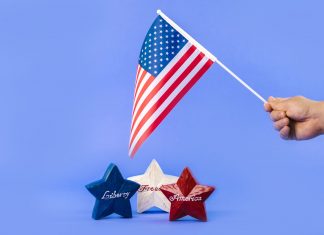 ÚLTIMA HORA: Nueva Jersey como país: un análisis audaz Hand holding American flag with red, white, and blue stars symbolizing liberty and freedom.