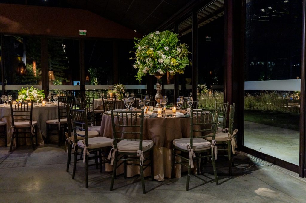 Luxurious indoor dining scene with floral decorations and elegant table settings.