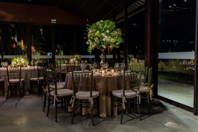 Luxurious indoor dining scene with floral decorations and elegant table settings.