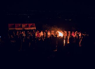 ÚLTIMA HORA: Varios eventos comunitarios para el 9-11 de junio en Hudson A large group of people gathered around a bonfire at night, featuring a vibrant outdoor atmosphere.