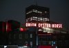 View of the illuminated Union Oyster House neon sign against a night sky in Boston.