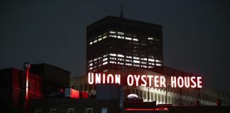 View of the illuminated Union Oyster House neon sign against a night sky in Boston.