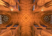 Intricate architecture and stained glass windows of St. Patrick's Cathedral ceiling in New York City.