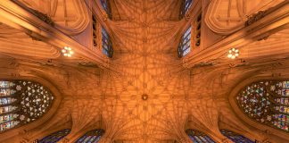 Intricate architecture and stained glass windows of St. Patrick's Cathedral ceiling in New York City.