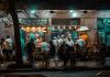 Crowded urban street restaurant at night, capturing lively city nightlife and dining.
