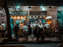 Crowded urban street restaurant at night, capturing lively city nightlife and dining.
