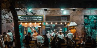 Crowded urban street restaurant at night, capturing lively city nightlife and dining.