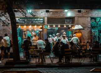 Los Mejores Restaurantes Abiertos Hasta Tarde en Hoboken: Guía 2026 para Comer de Noche Crowded urban street restaurant at night, capturing lively city nightlife and dining.