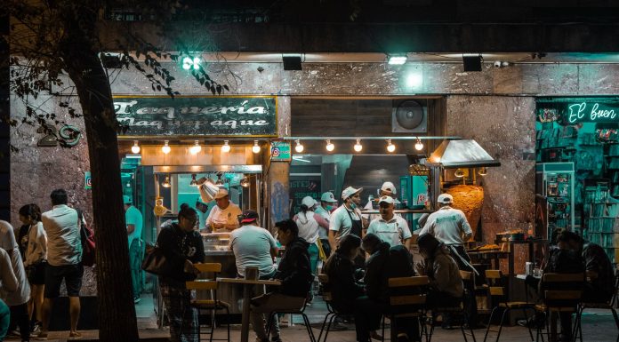 Los Mejores Restaurantes Abiertos Hasta Tarde en Hoboken: Guía 2026 para Comer de Noche Crowded urban street restaurant at night, capturing lively city nightlife and dining.