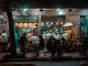 Crowded urban street restaurant at night, capturing lively city nightlife and dining.