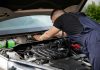 Los Mejores Talleres Mecánicos en Jersey City: Guía 2026 para tu Auto Auto mechanic performs engine maintenance on a car. Focus on hands and engine components.