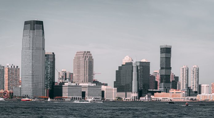 A breathtaking view of Jersey City's skyline from across the Hudson River with modern skyscrapers and waterfront buildings.