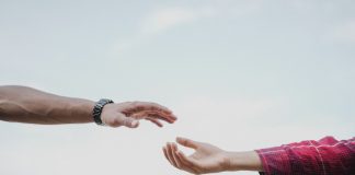 Two hands reaching towards each other, symbolizing connection and support.